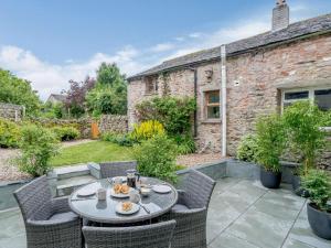 eine Terrasse mit einem Tisch und Stühlen vor einem Gebäude in der Unterkunft 2 bed in Eden Valley 83608 in Newby