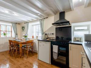 a kitchen with a table and a stove top oven at 2 bed in Tywyn 83956 in Abergynolwyn