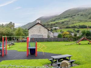 a park with playground equipment in front of a building at 2 bed in Tywyn 83956 in Abergynolwyn