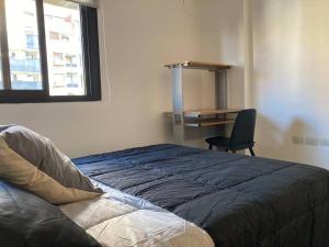 Schlafzimmer mit einem Bett, einem Schreibtisch und einem Stuhl in der Unterkunft Departamento increíble Nueva Córdoba, 4 personas in Cordoba