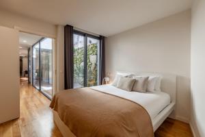 a bedroom with a large bed and a large window at Yellow Lodge - Minho's Guest in Braga