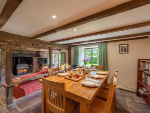 a dining room with a table and chairs and a fireplace at 4 Bed in Longtown 86497 in Llanveynoe