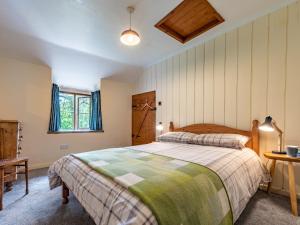 1 dormitorio con cama, mesa y ventana en 4 Bed in Longtown 86497 en Llanveynoe
