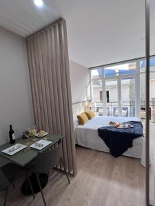 - une chambre avec un lit, une table et un bureau dans l'établissement Apartamentos San Juan Suites, à Badajoz