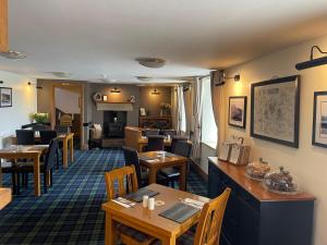 a restaurant with tables and chairs and a dining room at Redesdale Arms in Otterburn