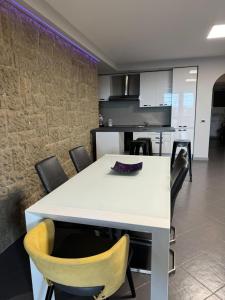 La casa di Gabry في ألبانو لاتسيالي: مطبخ وغرفة طعام مع طاولة وكراسي بيضاء