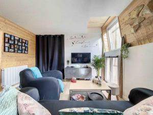 a living room with two blue chairs and a table at Le Wilson Cosy in Dijon