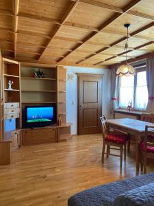 a living room with a table and a tv at Blick Tirol direkt auf der Skipiste in Mittersill