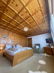 Blick Tirol direkt auf der Skipiste في ميترسيل: غرفة نوم بسرير وسقف خشبي