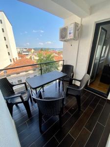 a patio with a table and chairs on a balcony at BK2 APARTMAN in Kragujevac