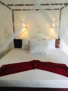 a bedroom with a white bed with white pillows at Anthony Guesthouse in Hikkaduwa