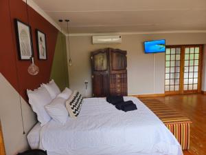 a bedroom with a large white bed in a room at Jacobsons Guesthouse in Bloemfontein
