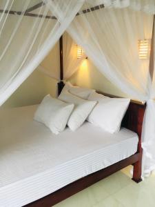 a bedroom with a bed with white pillows at Anthony Guesthouse in Hikkaduwa