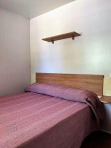 - une chambre avec un grand lit et une couverture violette dans l'établissement Bungalows Zaragoza Camping, à Saragosse