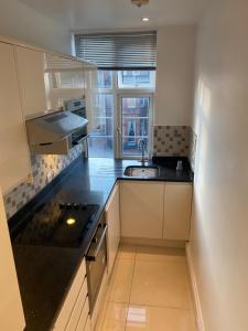 a kitchen with a sink and a stove at Central London Double Bedroom by Station in London