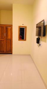 a room with a television and a white floor at PALM VISTA HOMESTAY in Malvan