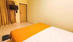 a room with a bed with an orange blanket at PALM VISTA HOMESTAY in Malvan