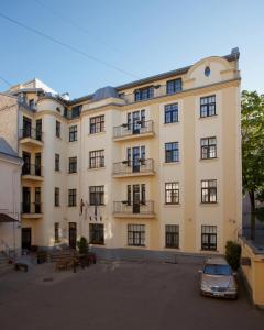 a large building with a car parked in front of it at Hotel Edvards in Rīga