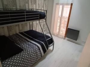 a bunk bed in a room with a window at logement entier avec garage. in Rieux
