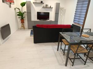 a living room with a table and a couch at logement entier avec garage. in Rieux