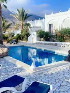 uma piscina com duas espreguiçadeiras ao lado de uma casa em BlueMar em Almeria