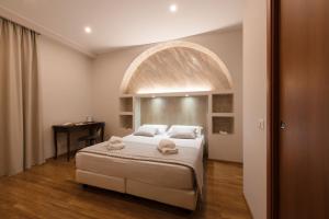 a bedroom with a large bed in a room with an arch at Top Floor Colosseo Guesthouse in Rome