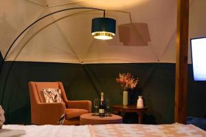 Cette chambre comprend une tente avec une chaise et une table. dans l'établissement Hillside Haven - (Luxury Geodome), à Portpatrick