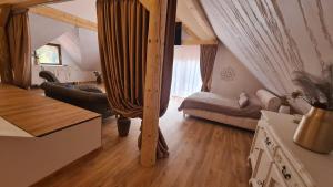 ein Wohnzimmer mit einem Loft mit einem Bett in der Unterkunft Conacul Radacinilor in Petroşani