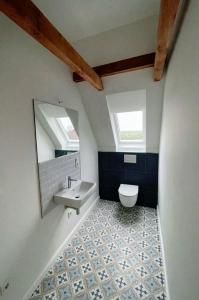 een badkamer met een wastafel en een toilet bij Ferienwohnung-An-t-Osterdiek in Neßmersiel