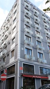 un edificio alto gris con ventanas en una calle en Star City Hotel, en Estambul