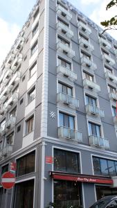 wysoki szary budynek z oknami wychodzącymi na ulicę w obiekcie Star City Hotel w Stambule