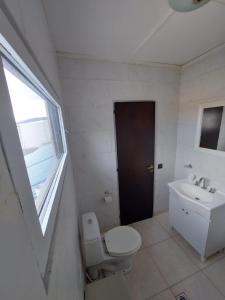 uma casa de banho com um WC, um lavatório e uma janela em Habitación con Baño Privado - Frigo bar y sector para desayunar - Sin cocina em Ushuaia
