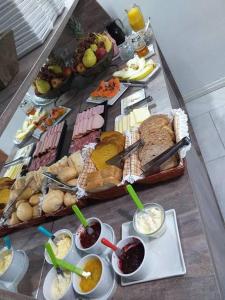uma mesa com diferentes tipos de alimentos e bebidas em Pousada águia da serra em Gramado