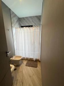 ein Bad mit einem WC und einem weißen Duschvorhang in der Unterkunft Country Vera Terra. Yerba Buena. Tucumán in Yerba Buena
