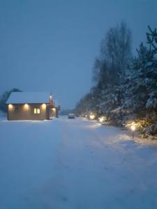 uma casa na neve à noite com luzes em Domki Dębowe Wzgórze em Potok Złoty