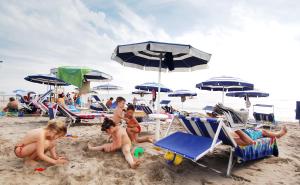 a group of children playing in the sand at the beach at Camping Internazionale - Sottomarina di Chioggia in Chioggia