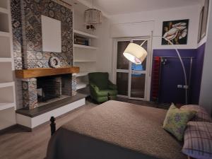 a bedroom with a fireplace and a green chair at Pet's Friendly House in Quattromiglio