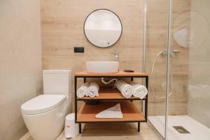 uma casa de banho com um WC, um lavatório e um espelho. em RINCON DE LA CRUZ 2B em Caravaca de la Cruz