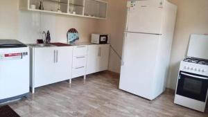 uma cozinha com electrodomésticos brancos e um frigorífico branco em Big Seafront Apartment in Saida Lebanon em Saïda