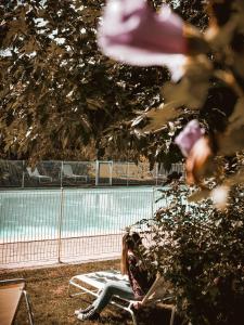 un banc installé dans l'herbe à côté d'un court de tennis dans l'établissement Castel Novel, à Varetz