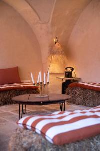 een kamer met banken en een tafel met kaarsen bij Antica Masseria le Monache in Grottaglie