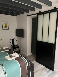 1 dormitorio con 1 cama y TV en una habitación en Loft relais Cœur de France en Vierzon
