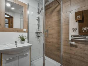un baño con ducha y lavabo en Villa Julia - apartamenty widokowe, en Biały Dunajec 27 fotos más