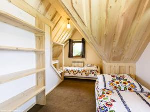 Dos camas en una habitación con techos de madera. en Villa Julia - apartamenty widokowe, en Biały Dunajec
