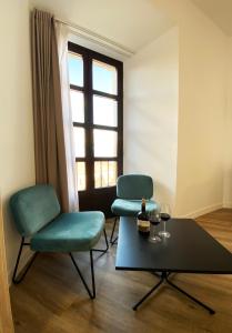 Duas cadeiras e uma mesa num quarto com uma janela em Casa Vargas Figueroa restaurante Casa del Sol em Cáceres