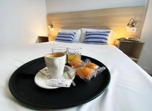 a tray of food and a cup of coffee on a bed at Hostel Casa Vargas Figueroa in Cáceres