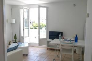 a white living room with a table and a television at Plus qu'à s'installer,pour des séjours télétravail in Rhut