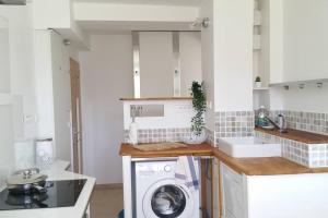a white kitchen with a washing machine in it at Plus qu'à s'installer,pour des séjours télétravail in Rhut