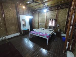 Una habitación con una cama en el medio. en Vasant Bamboo Cottage en Maheshwar