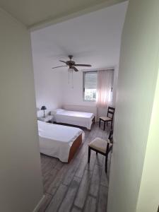 1 dormitorio con 2 camas y ventilador de techo en apartamento en EDIFICIO URUGUAY 8VO, en Punta del Este